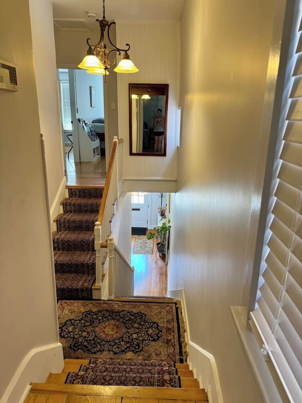 A staircase with patterned carpet leading to a second-floor landing.